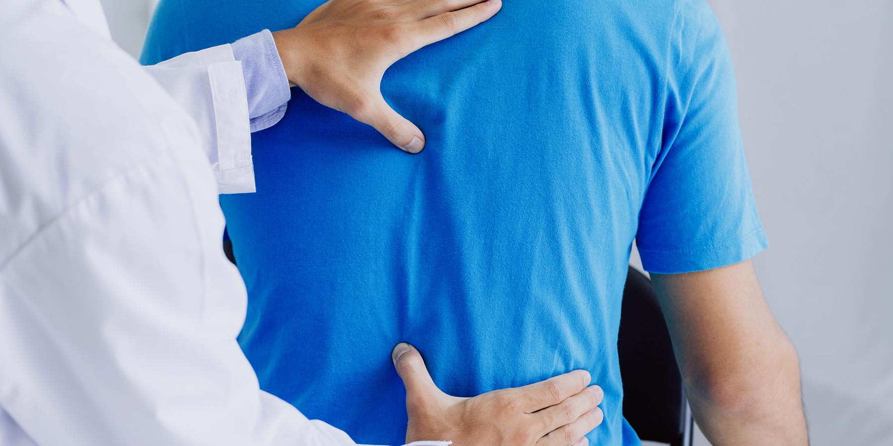 A male patient is undergoing a lumbar assessment conducted by a specialized neurosurgeon.