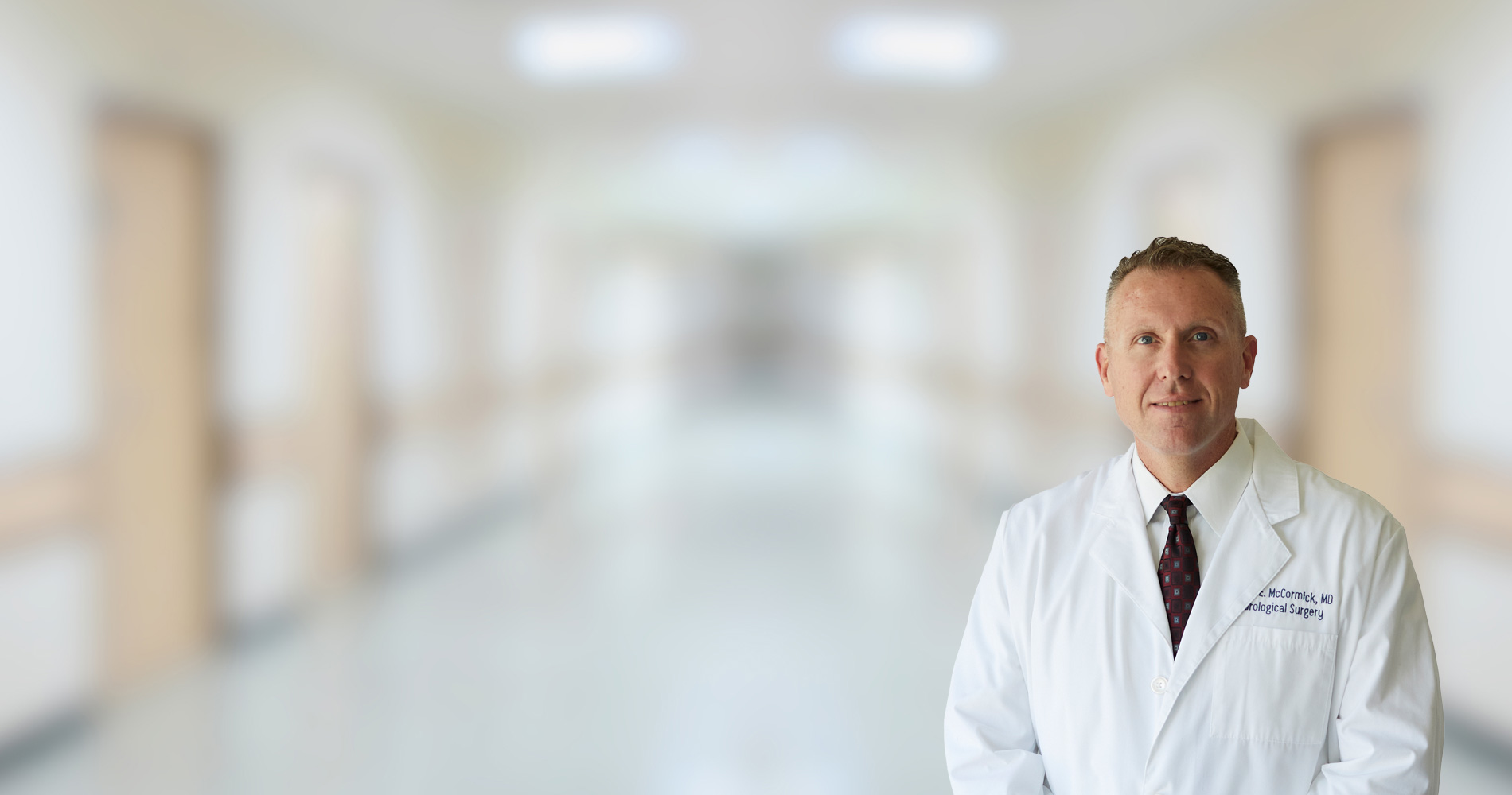 A neurosurgeon, impeccably attired in a pristine white lab coat, is positioned along the corridor of the medical establishment.