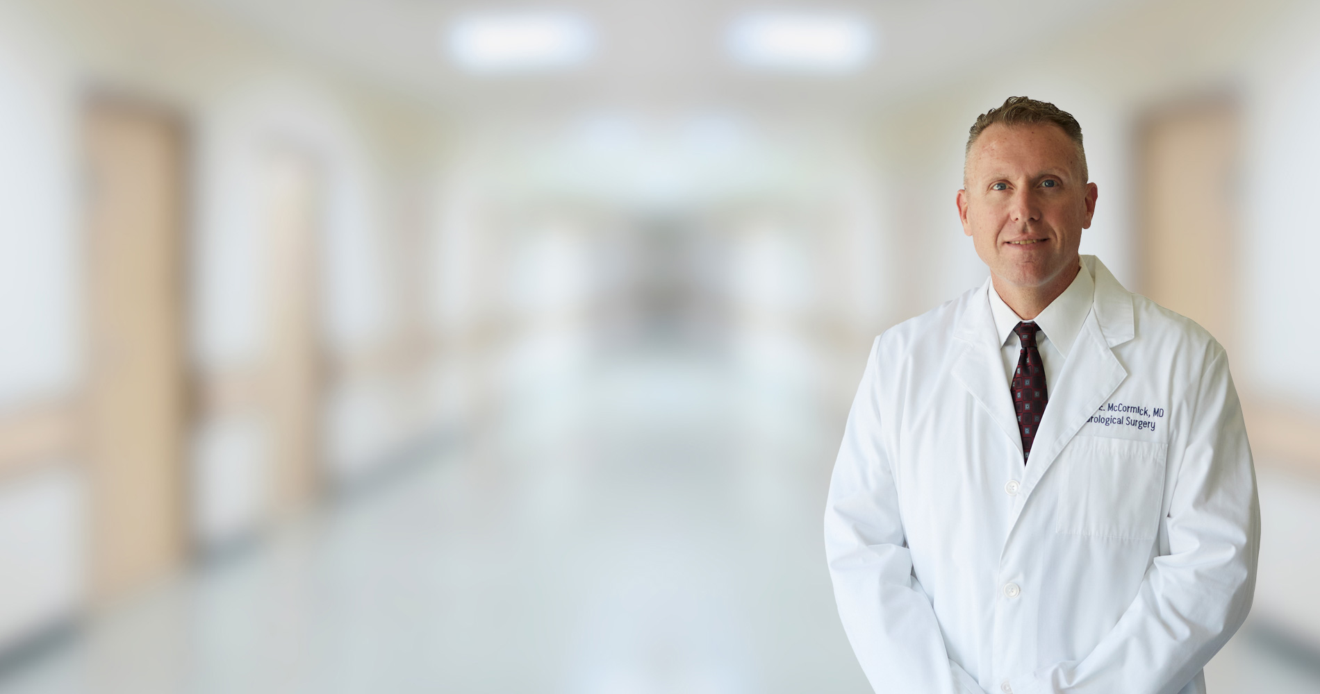 A distinguished neurosurgeon, attired in pristine white ward attire, is poised in the clinical corridor.